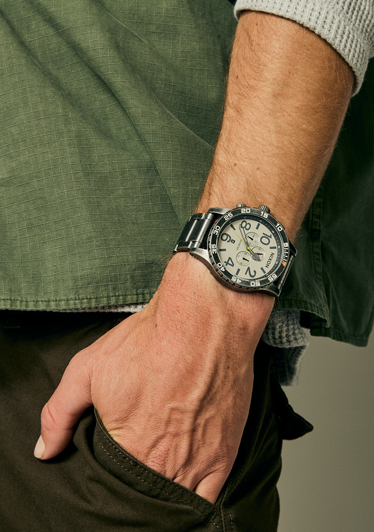 Man wearing a Nixon 51-30 Chrono analog watch with his hand in his pocket